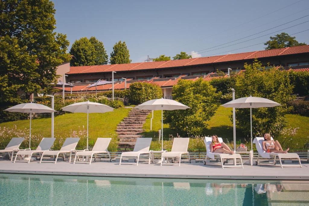 - un groupe de personnes assis sur des chaises à côté d'une piscine dans l'établissement Hotel Horizon Wellness & Spa Resort - Best Western Signature Collection, à Varèse