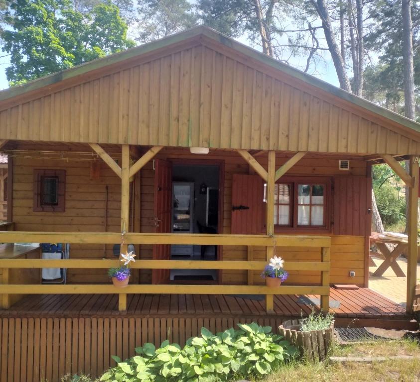 a log cabin with a porch and a deck at Domek MONA-3pokojowy- przy morzu in Krynica Morska