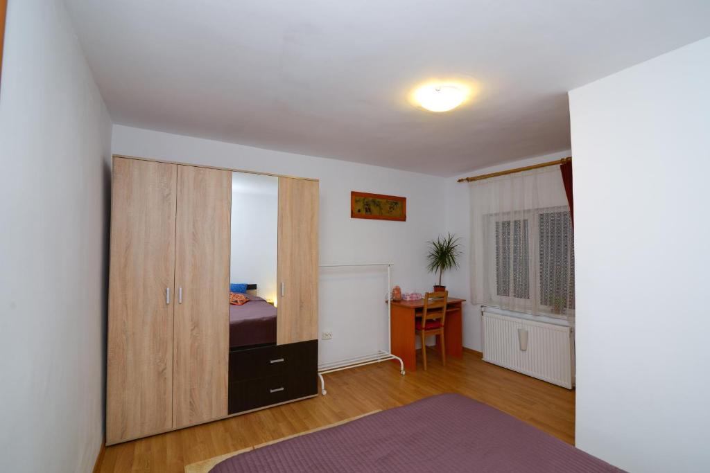 a bedroom with a closet and a bed and a desk at Otopeni Airport Apartment in Otopeni
