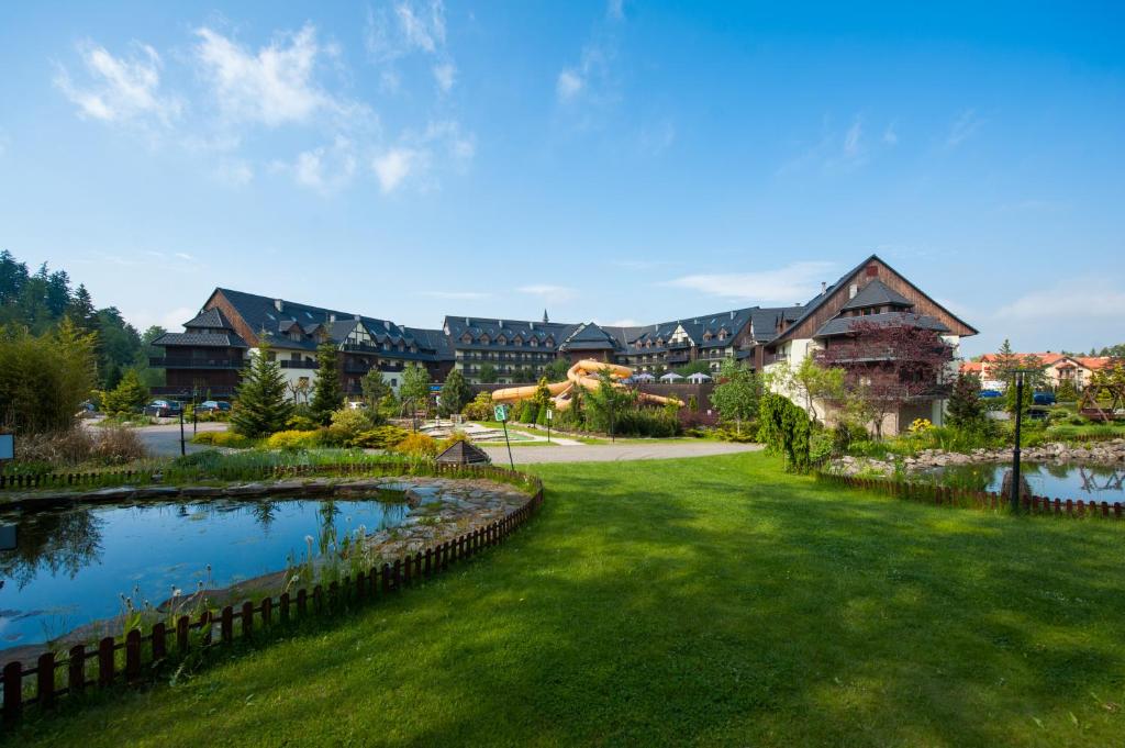 a resort with a pond in the middle of a yard at Sandra Spa Karpacz & Aquapark in Karpacz