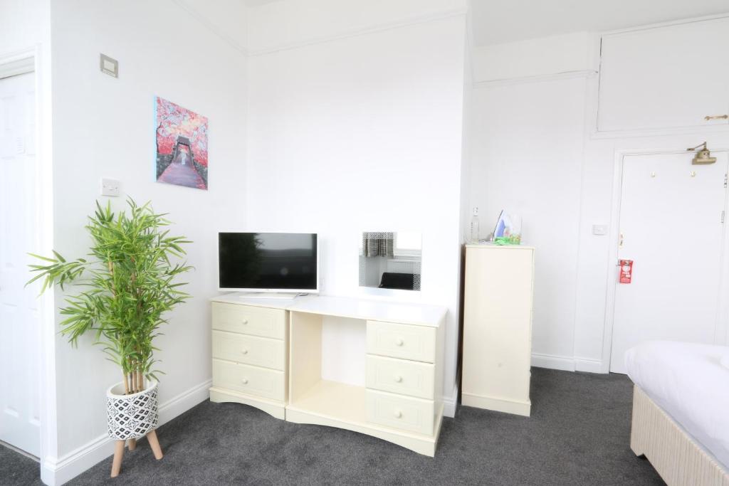 1 dormitorio con TV y vestidor blanco en Sunnydene, en Great Yarmouth