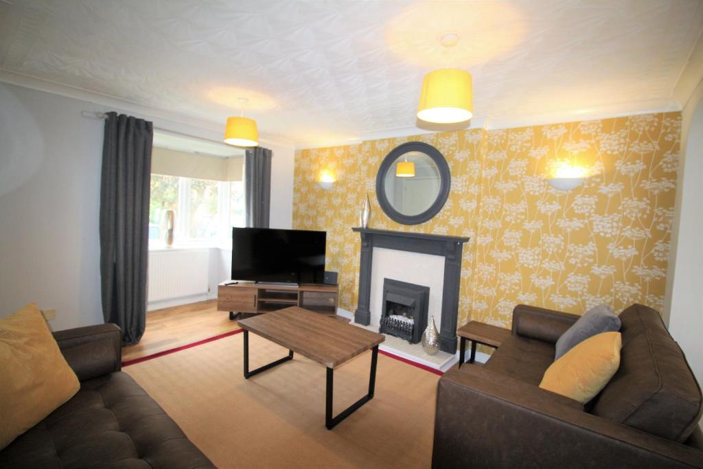 a living room with a couch and a fireplace at 3 Bed Detached - 3 Bathrooms - Parking - Quiet in Doncaster
