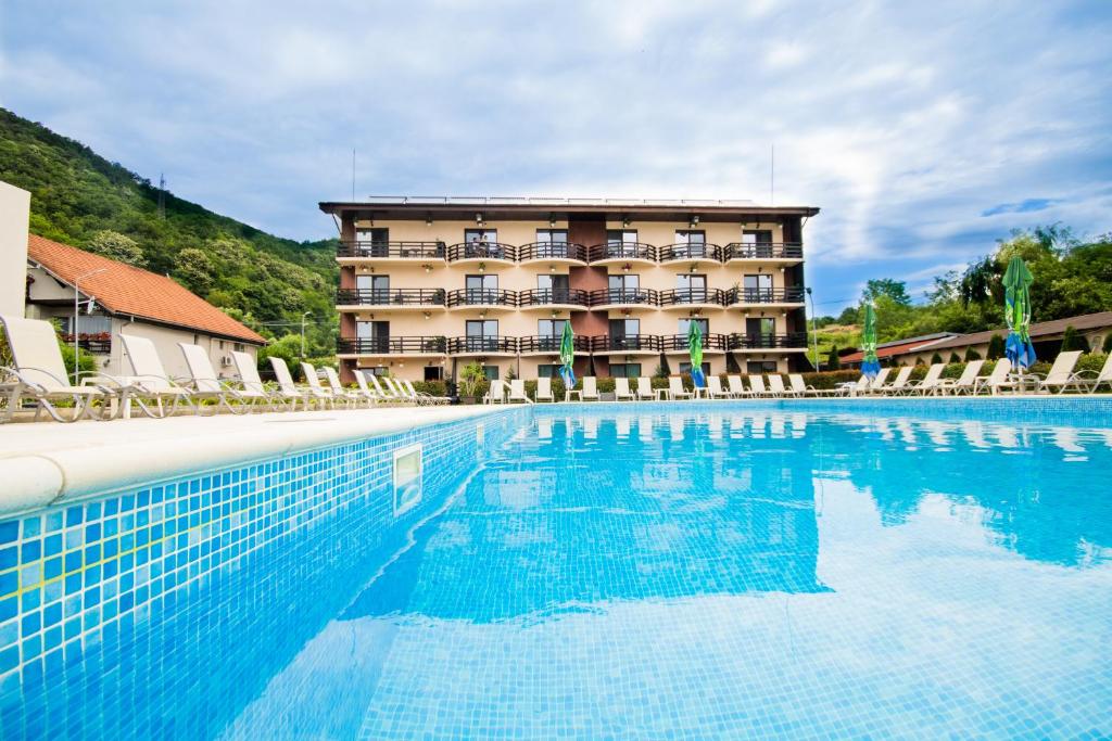 ein Hotel mit einem Pool vor einem Gebäude in der Unterkunft Pensiunea Danubia in Eşelniţa