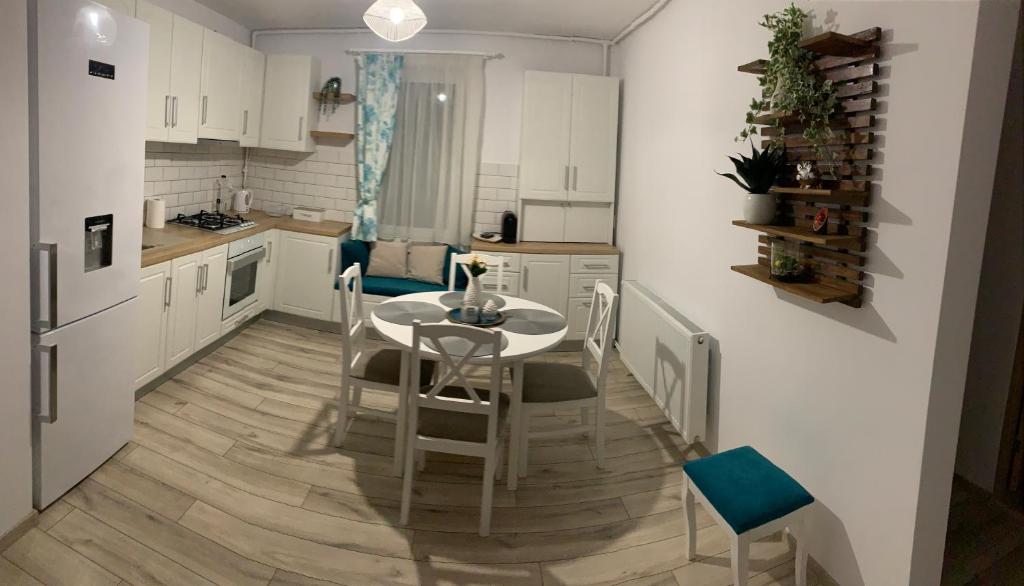 a kitchen with a table and chairs in a kitchen at NELI HOME Apartament in Reghin