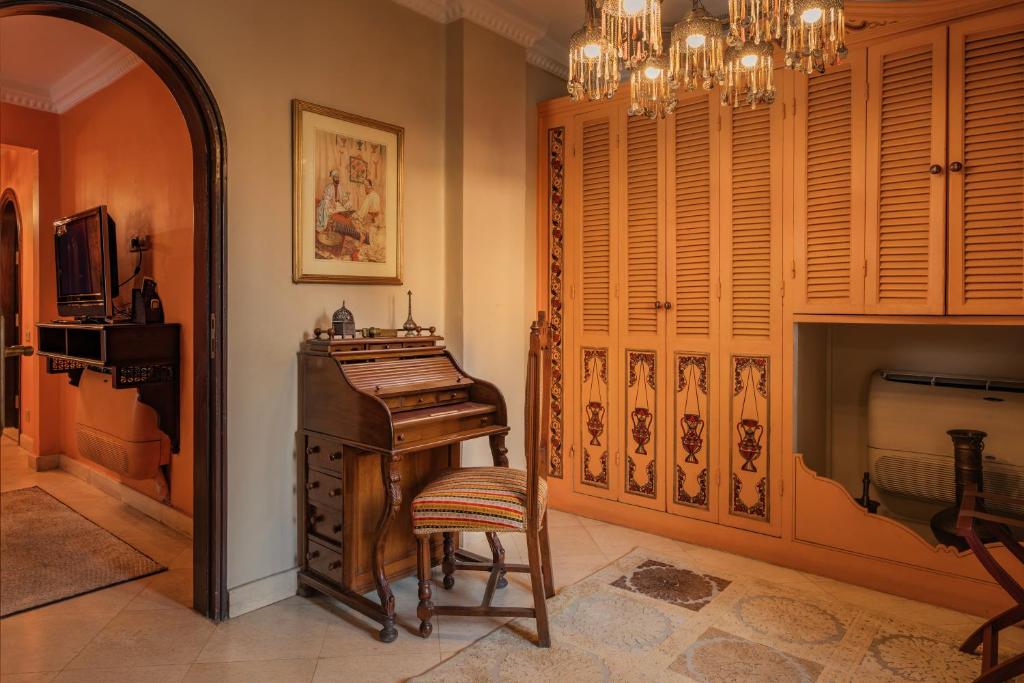 a room with a piano and a chair and a mirror at Le Riad Hotel de Charme in Cairo