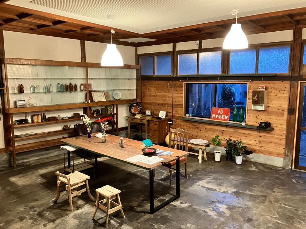 een grote kamer met een houten tafel en stoelen bij Stay Do in Oshima