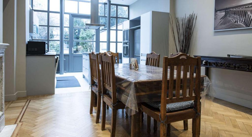 een eetkamer met een tafel en stoelen in een keuken bij Chic 3-bedroom apartment for rent to professionals in Ixelles in Brussel