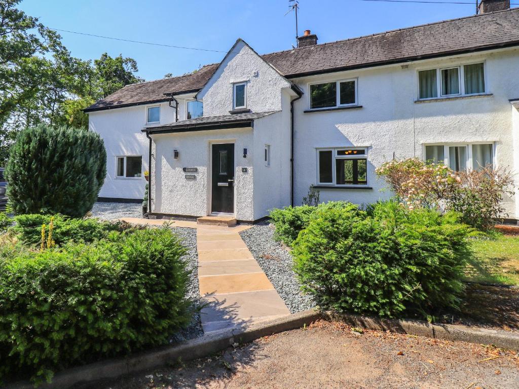 a white house with a pathway in front of it at Ellerbeck Bridge in Kendal