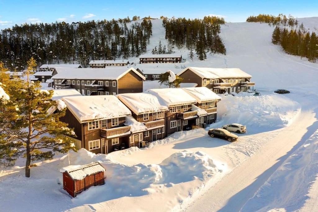 Koselig leilighet i hytteområde på Gautefall في Drangedal: اطلالة جوية على منتجع في الثلج