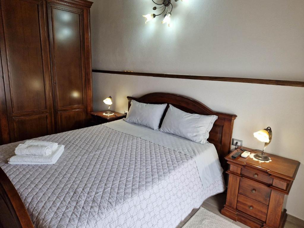 a bedroom with a bed with two nightstands and two lamps at Appartamento Filomena scano di montiferro in Scano Montiferro