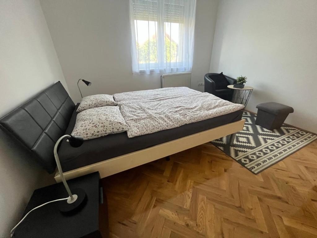Schlafzimmer mit einem Bett und Holzboden in der Unterkunft Luca Vendégház 1. apartman in Sárvár