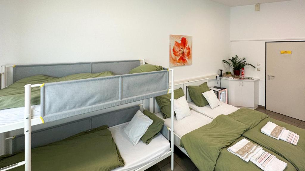 a bedroom with two bunk beds with green sheets at Mali Schachmuseum in Klagenfurt