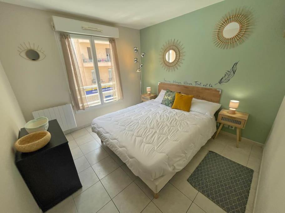 sypialnia z dużym łóżkiem i oknem w obiekcie T2 Moderne Proche du port - CLIM w Nicei