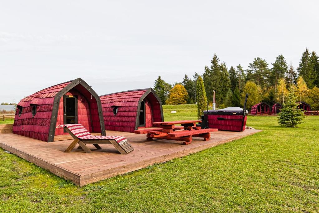 a red barn with a picnic table and a bench at Saare Paadiküla 