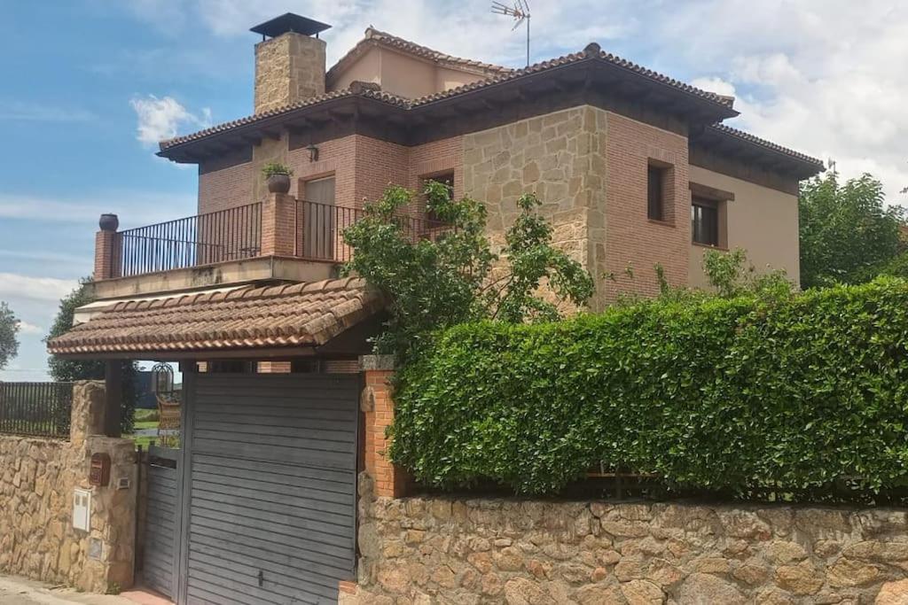 uma casa com um portão e uma parede de pedra em Villa Juan em La Adrada