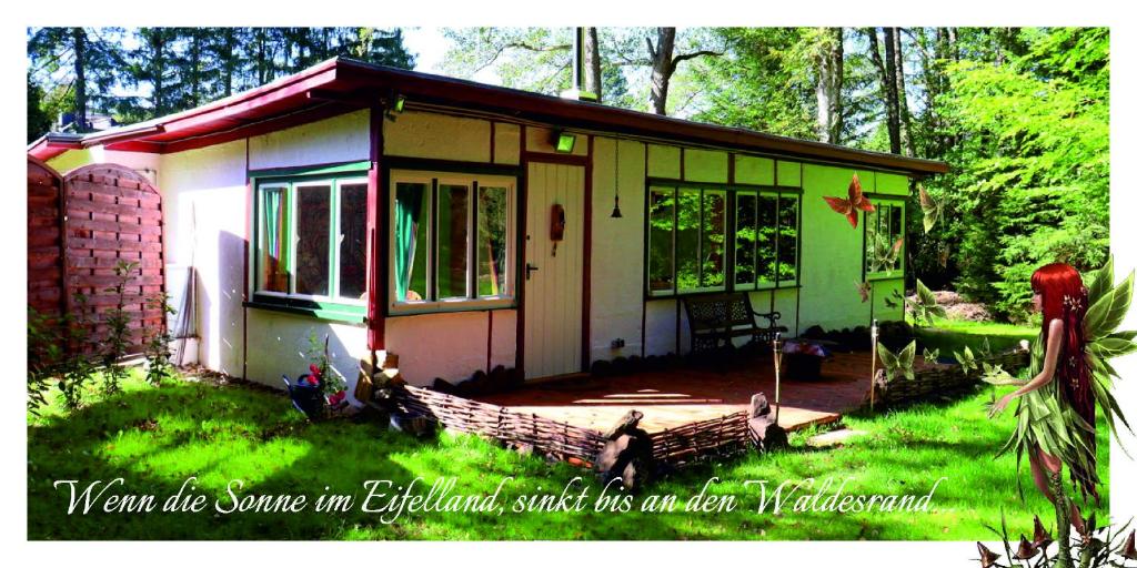 a small house in the middle of a yard at Elfenhütte Ferienhaus Eifel in Rott