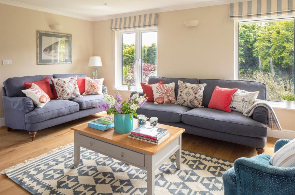 uma sala de estar com dois sofás e uma mesa de centro em High Meadows em Saint Mawes