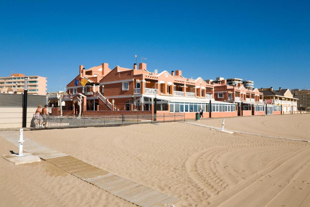 a building on the beach next to a sandy beach at Lloyds Beach Club in Torrevieja
