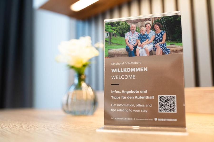 a sign sitting on a table with a vase of flowers at Ringhotel Schlossberg in Neustadt