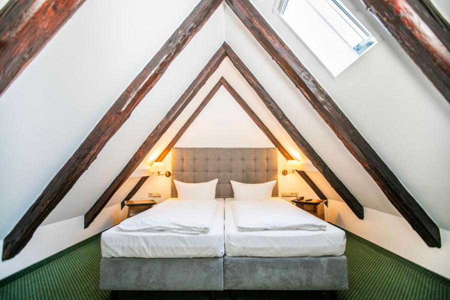 a bed in a room with a roof at Ringhotel Schlossberg in Neustadt