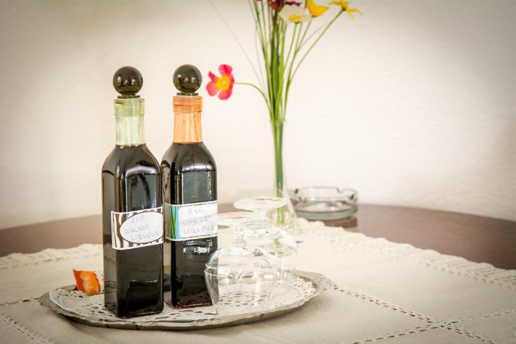 two bottles of wine on a table with a vase of flowers at Apartments Bongavila in Podstrana