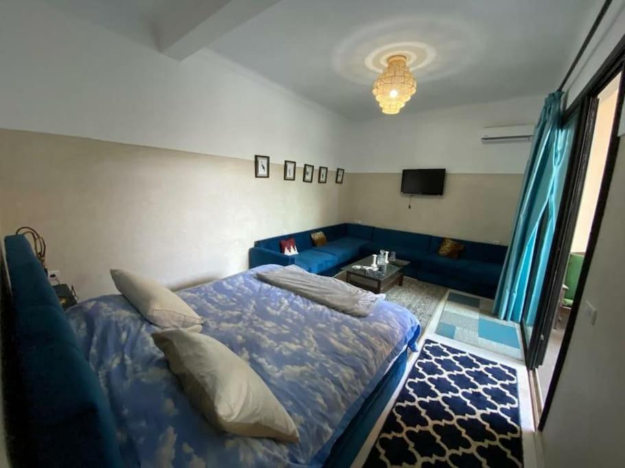 a bedroom with a blue bed and a blue couch at Douiria salix agafay in Marrakech