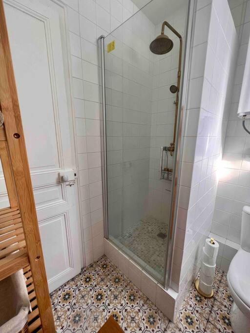a bathroom with a shower with a glass door at Paris Home in Boulogne-Billancourt