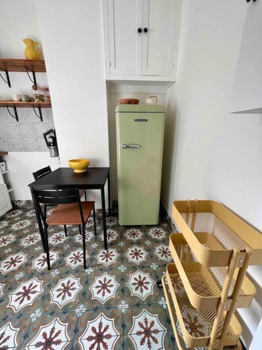 a kitchen with a green refrigerator and a table at Paris Home in Boulogne-Billancourt