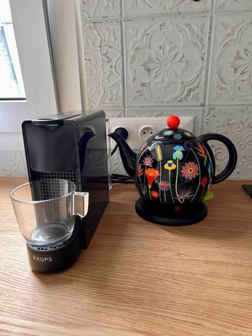 a tea pot sitting on a table next to a microwave at Paris Home in Boulogne-Billancourt