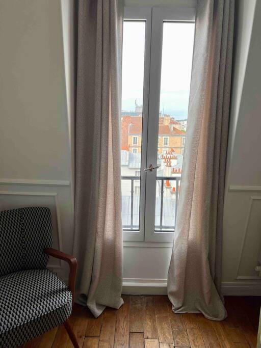 a room with a chair and a window with a view at Paris Home in Boulogne-Billancourt