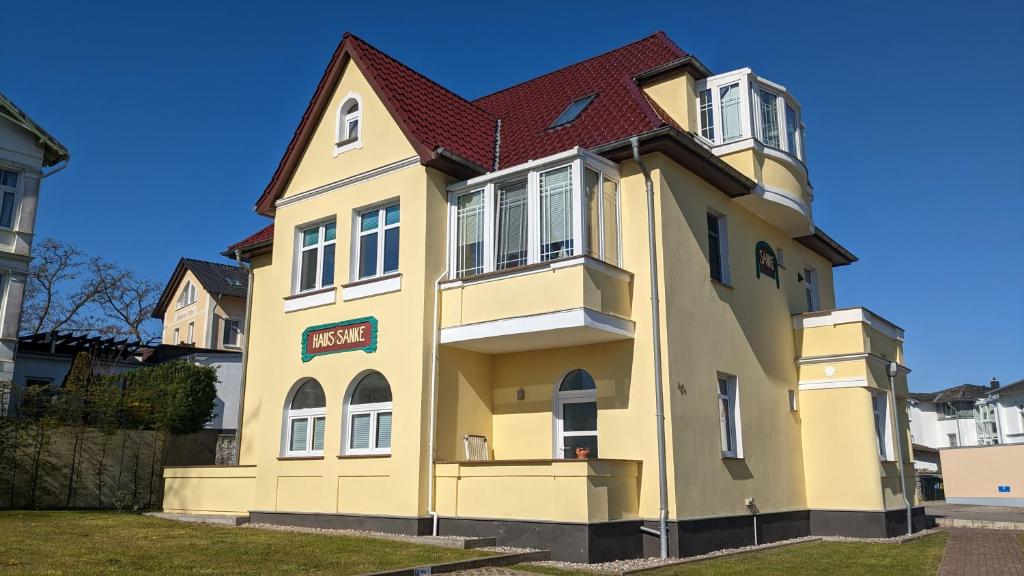 ein gelbes Haus mit rotem Dach in der Unterkunft Haus Sanke strandnah in Ahlbeck