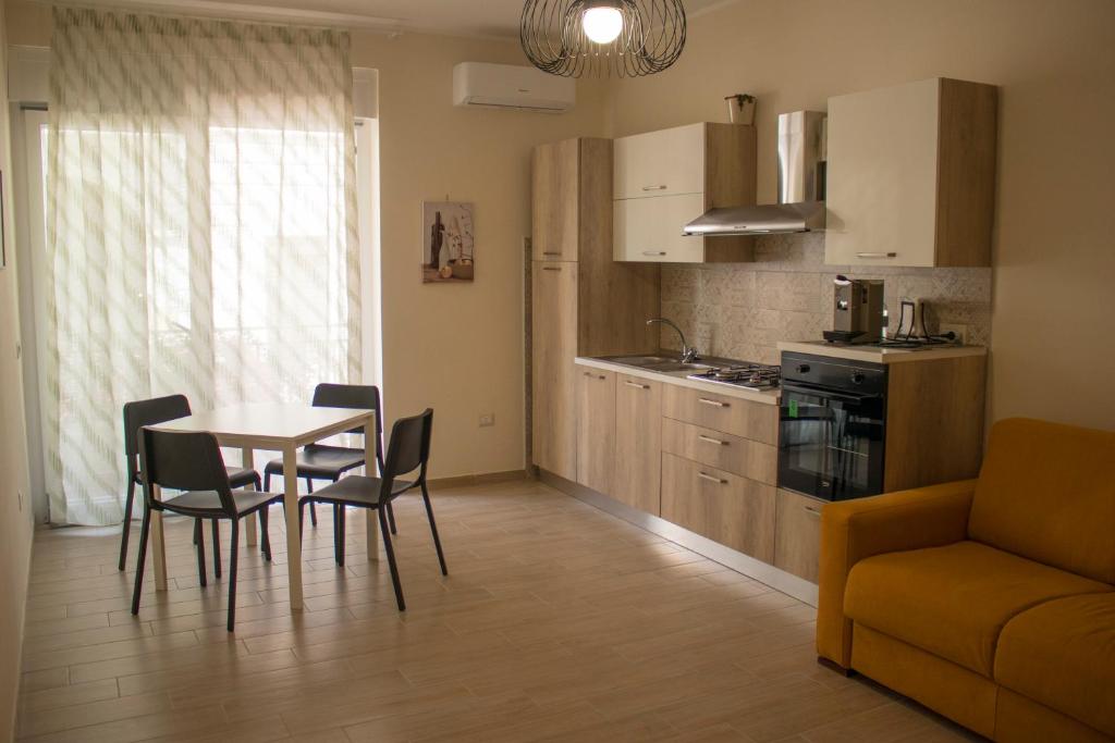 cocina con mesa, sillas y sofá en Appartamento via Roma, en Recale