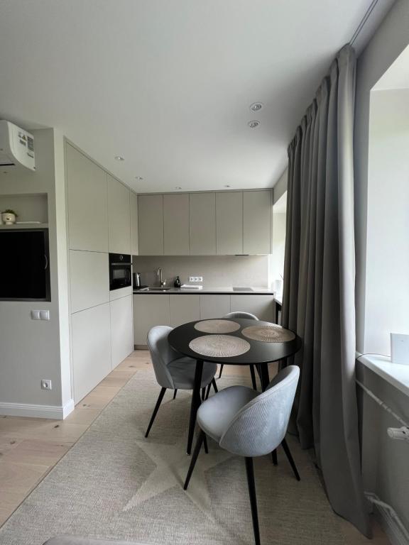 a kitchen with a table and chairs in a room at Biliūno apartamentai prie jūros in Palanga