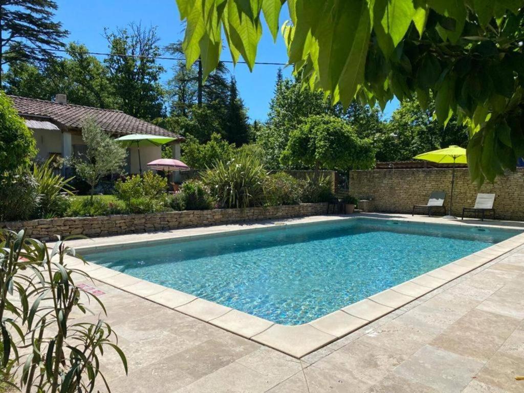 a swimming pool in the backyard of a house at Gîte La loge 142 route de CARPENTRAS 84210 VENASQUE in Venasque