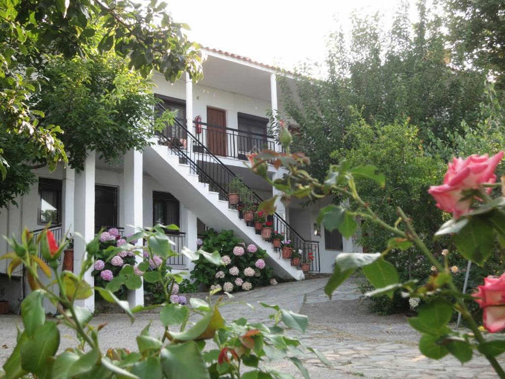 a building with stairs and flowers in front of it at Panagiotis Apostoloudias Rooms in Therma
