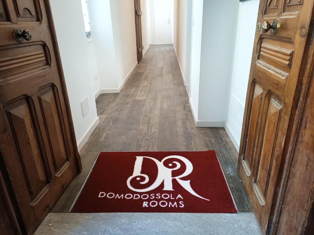 a red welcome mat on the floor of a hallway at Alloggio delizioso DOMODOSSOLA ROOMS in Domodossola