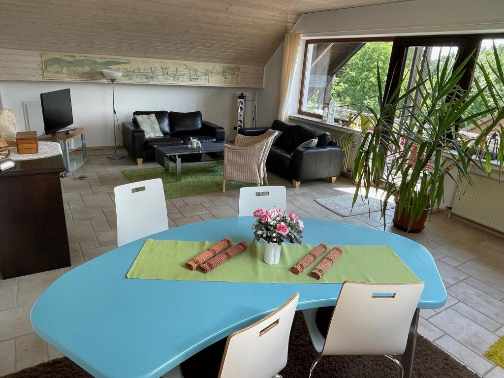 una mesa azul y sillas en la sala de estar en Haus am Oberen Eschenbacher Teich, en Clausthal-Zellerfeld