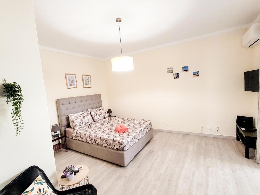 a white bedroom with a bed and a table at Reis Turismo in Faro