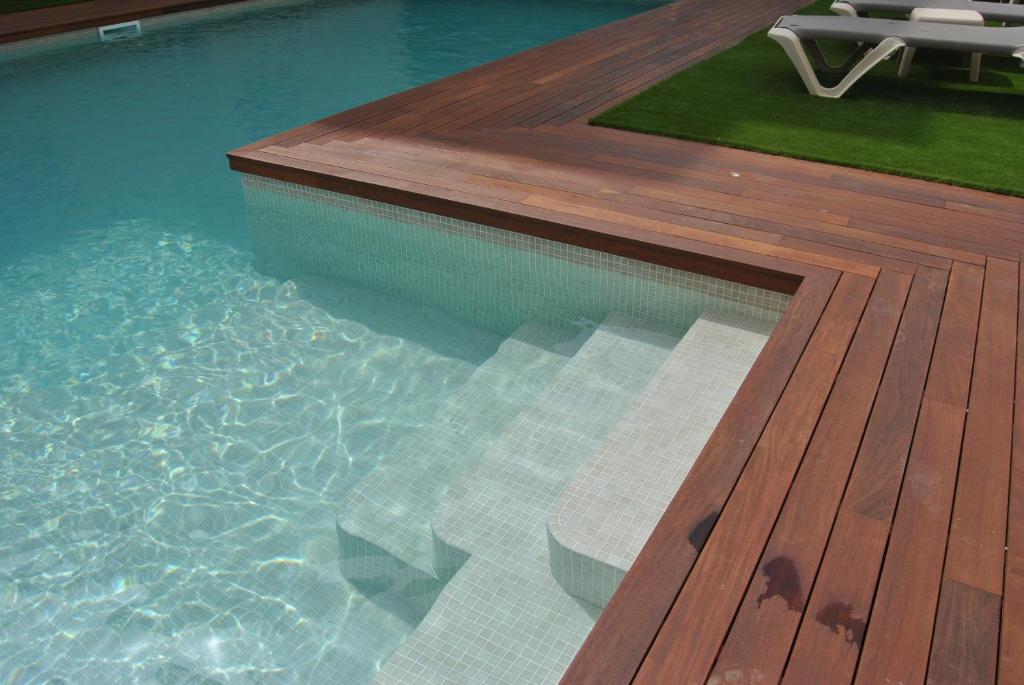 a swimming pool with a wooden deck next to a swimming pool at Hotel Bell Aire in L'Estartit