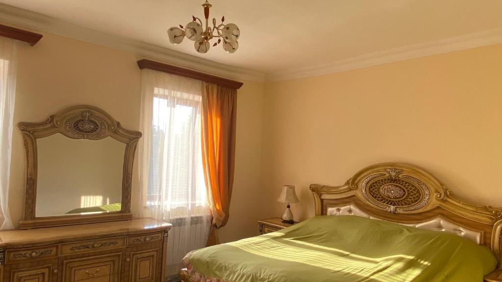 a bedroom with a bed and a mirror and a dresser at Asatryan’s Guest House in Vagharshapat