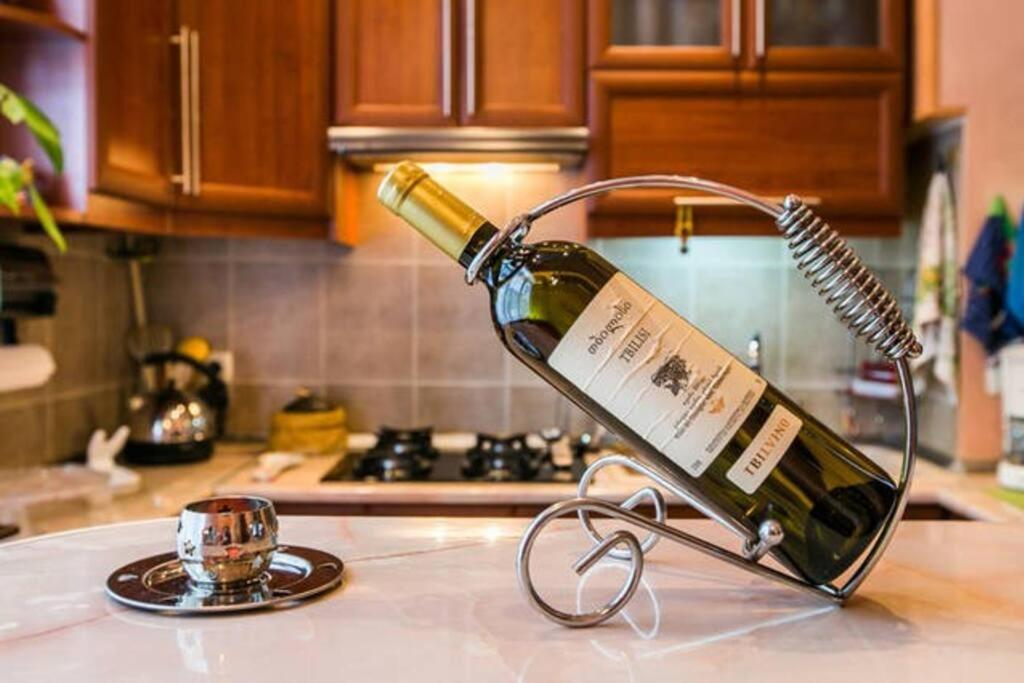 a bottle of wine on a counter in a kitchen at Уютная квартирка в центре Тбилиси! in Tbilisi City
