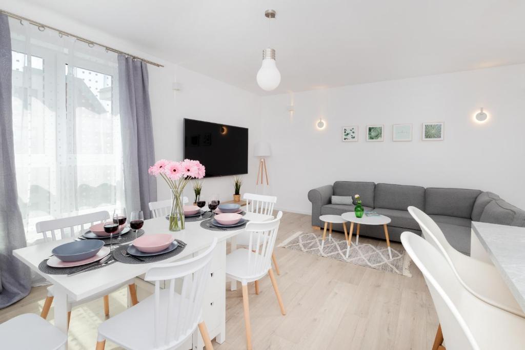 a living room with a white table and chairs at Garnizon Apartment for 6 Guests with Parking & Balcony by Renters in Gdańsk