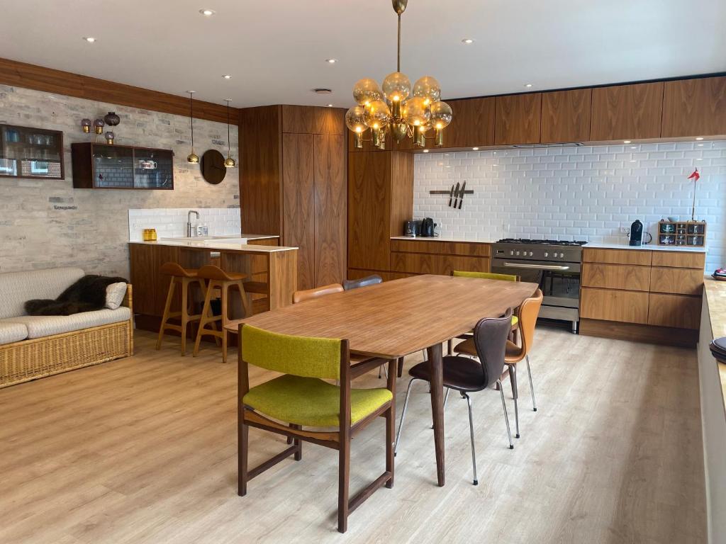 a kitchen and dining room with a wooden table and chairs at Aalborg - Beautifully renovated luxus apartment in Aalborg