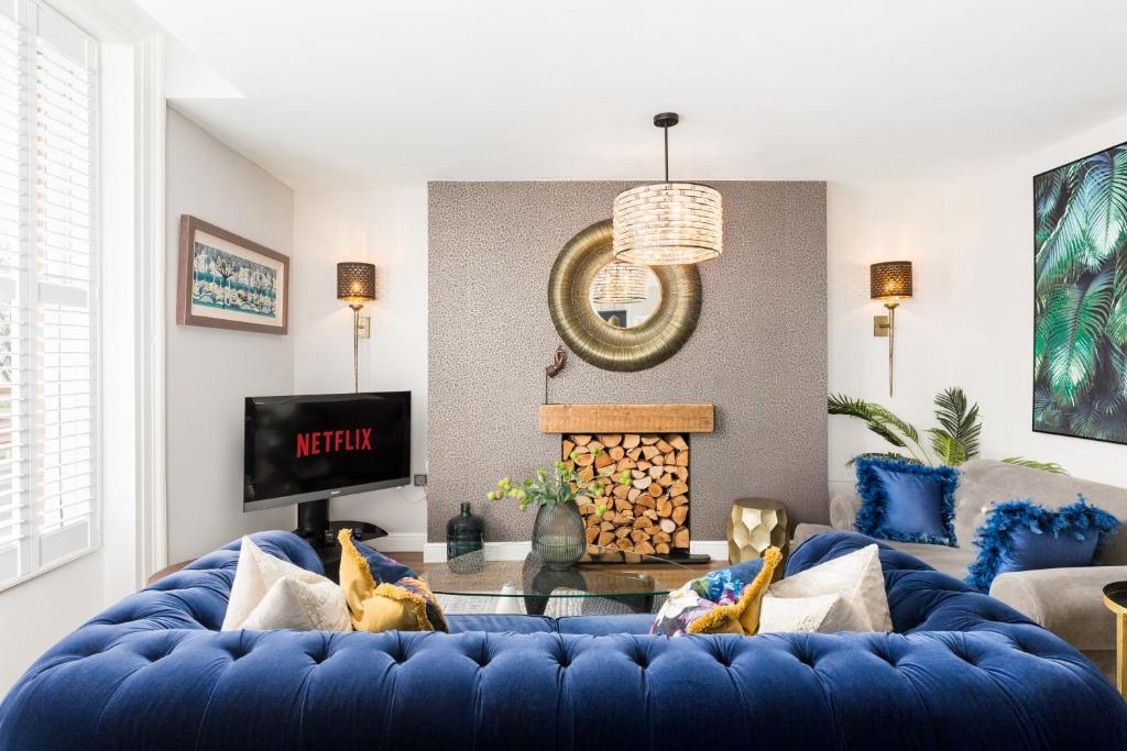 a living room with a blue couch and a fireplace at The Shirt Factory Apartments in Warrington