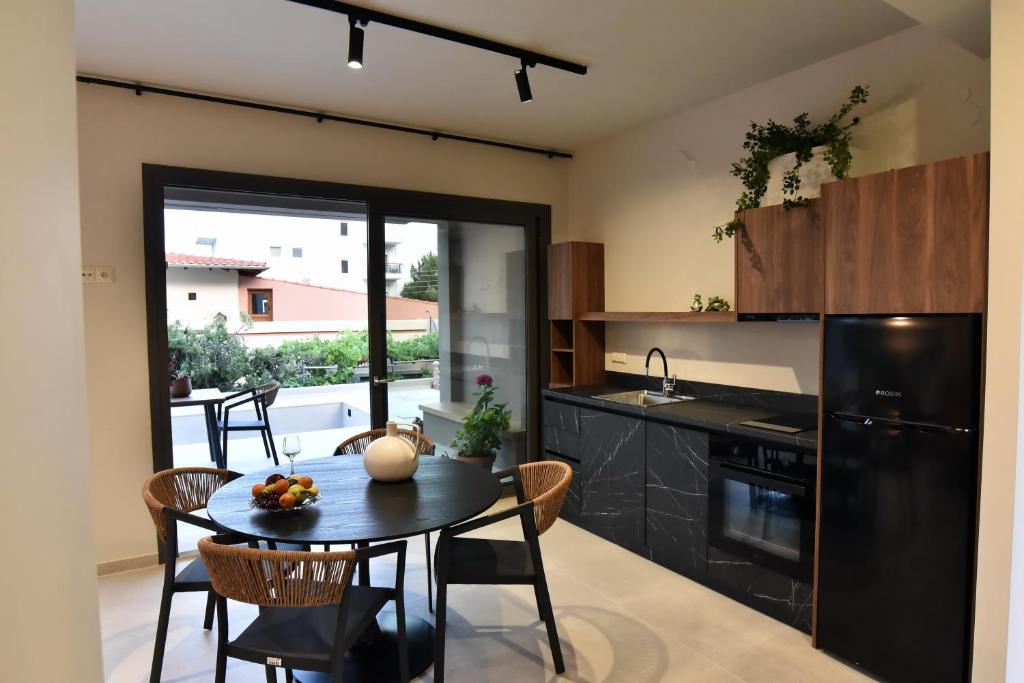 a kitchen with a table and chairs and a refrigerator at Welcome Inn in Paleo Tsifliki