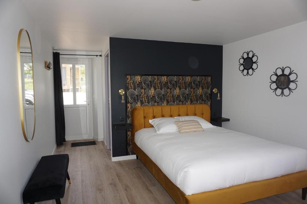 ein Schlafzimmer mit einem großen weißen Bett und einem Spiegel in der Unterkunft Riva Studio in Saint-Aignan