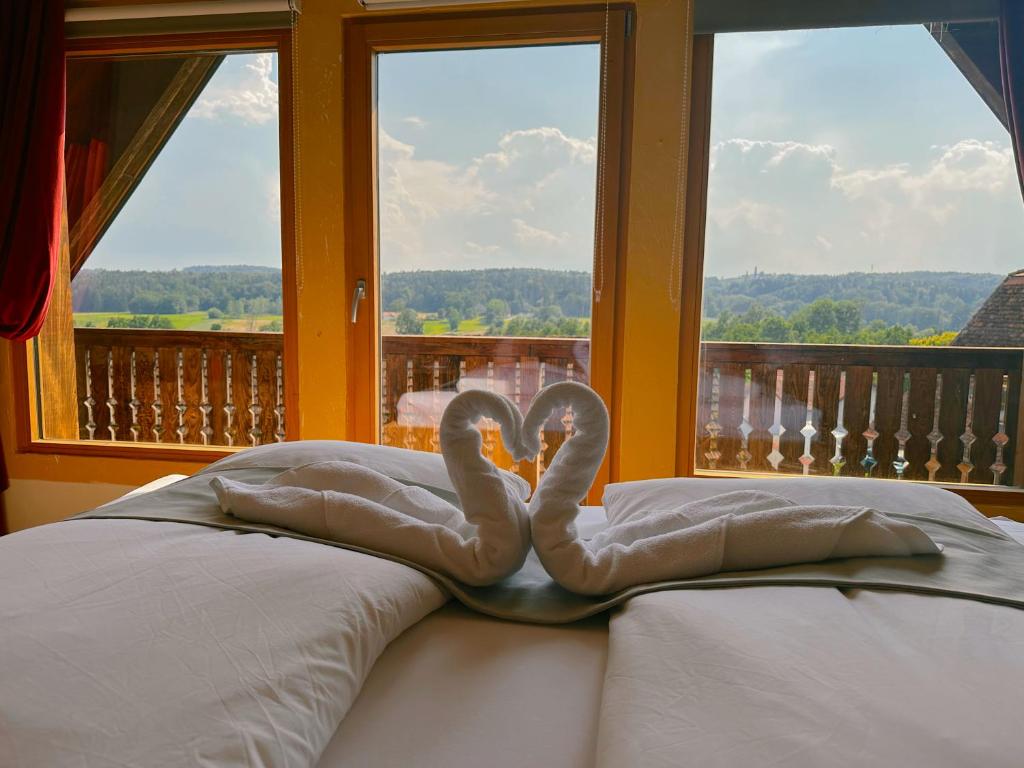 a swan decoration on a bed in front of a window at Romantisches Wellness Chalet im steirischen Ursprung 