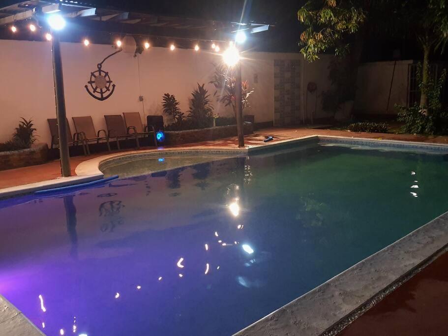 an empty swimming pool at night with lights at Casa Elohim in Iztapa