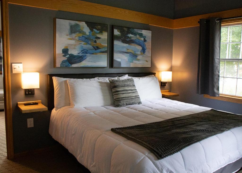 a bedroom with a large bed with two lamps at New England Inn & Lodge in North Conway
