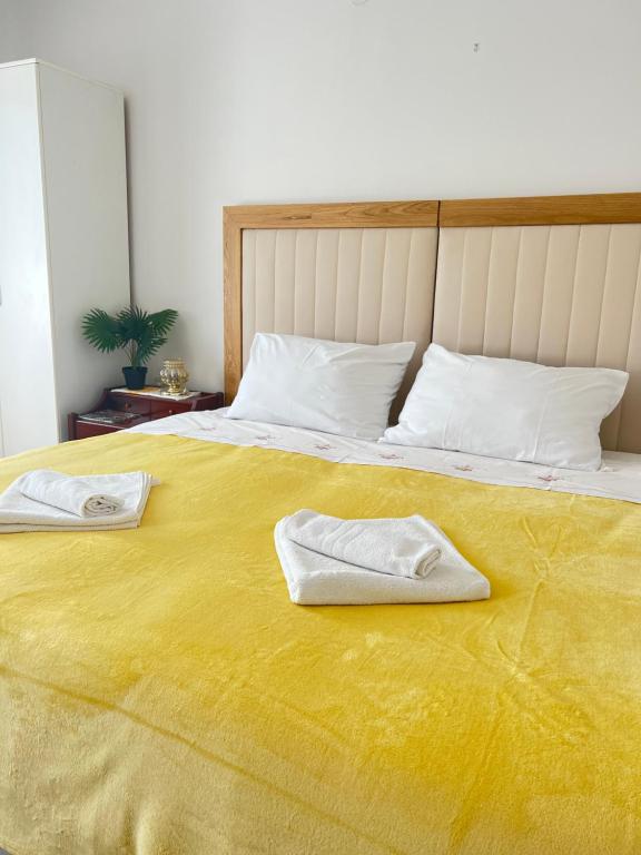 żółte łóżko z dwoma ręcznikami na górze w obiekcie Apartment Silvana w Szybeniku